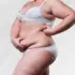 woman holding her extra skin and fat after weight loss as she contemplates body lift costs