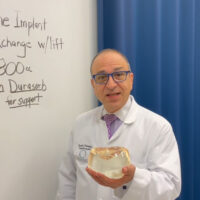 Dr. Rodriguez holding a large breast implant