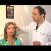 Dr. Ricardo L. Rodriguez showing the area on a patient's face that will be treated.