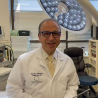 Dr. Rodriguez standing in his Baltimore plastic surgery center OR holding a liposuction cannula